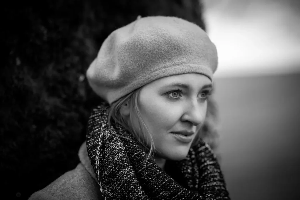 Porträt einer Frau mit Mütze und Schal im Freien – weiches Licht, Schwarzweiß