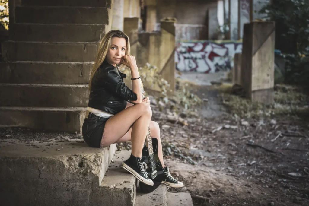 Portrait einer Frau mit Gitarre in einem Lostplace-Umfeld